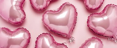 Pembe arka planda kalp şeklinde pembe hava balonları. Sevgililer Günü için konsept, dekorasyon, düğün, davetiye ya da fotoğraf bölgesi. Folyo topları. Pankart. Düz yatış, üst görünüm
