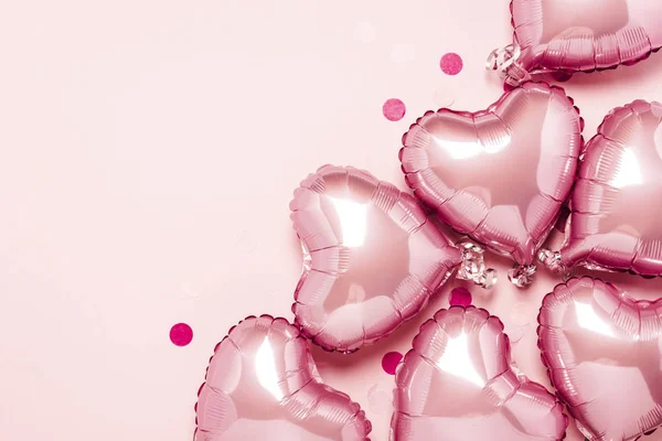 Des ballons à air rose en forme de cœur sur fond rose. Concept pour la Saint Valentin, décoration, mariage, invitation ou zone photo. Des boules de papier. Couché plat, vue du dessus — Photo