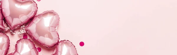 Różowe balony w kształcie serca na różowym tle. Pomysł na Walentynki, dekoracje, ślub, zaproszenie lub strefę fotograficzną. Foliowe kulki. Sztandar. Płaskie ułożenie, widok z góry — Zdjęcie stockowe