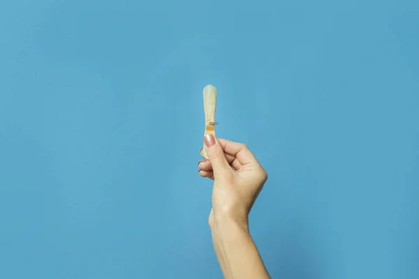 Main féminine tient un bâton de crème glacée sur un fond bleu. Concept d'été chaud, une paire d'amoureux, amoureux. Couché plat, vue du dessus — Photo