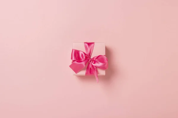 Rózsaszín ajándékdoboz rózsaszín szalaggal, rózsaszín háttérrel. Esküvői fogalom, Valentin nap, ajándék a szeretteidnek. Zászlós. Lapos fekvésű, felülnézet — Stock Fotó