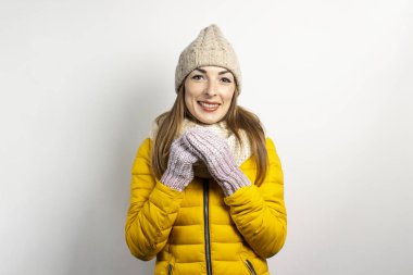 Kış örgü şapkalı, atkılı ve sarı ceketli genç bir kadın. Kış konsepti, kış modası, kış kıyafetleri