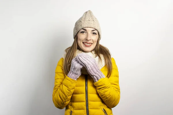 Mulher jovem em um chapéu de malha de inverno, lenço e jaqueta amarela em um contexto leve. Conceito de inverno, moda de inverno, roupas de inverno — Fotografia de Stock