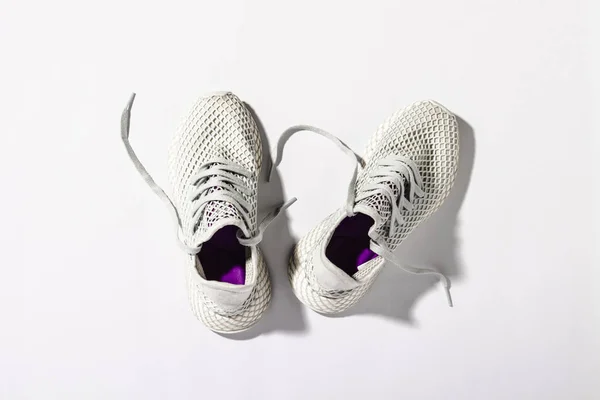 Sneakers on a white background under the morning sun. The concept of running, fitness, cross fit. Morning running. Natural light. Flat lay, top view — Stockfoto