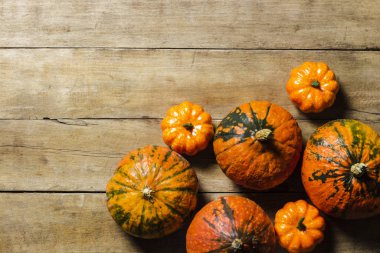 Ahşap bir arka planda olgun balkabakları. Hasat konsepti, sonbahar, Cadılar Bayramı arifesi. Pankart. Düz yatış, üst görünüm