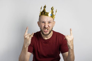 Kafasında taç olan genç adam seviniyor ya da arka planda bir şeyleri kutluyor. Kavram, kral, şans, kazanç, zenginlik, hayal, amaç, istektir. Pankart