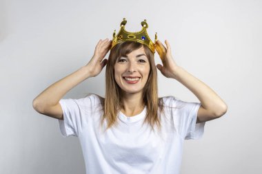 Kafasında tacı olan genç bir kadın. Duygusal kahkaha, sürpriz, öpücük. Kraliçe konsepti, şans, en iyisi, kazanmak, zafer. Pankart