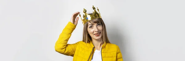 Mladá žena ve žlutém saku a s korunou na hlavě na lehkém pozadí. Emoční smích, překvapení, polibek. Koncept královny, štěstí, to nejlepší, vítězství, vítězství. Nápis — Stock fotografie