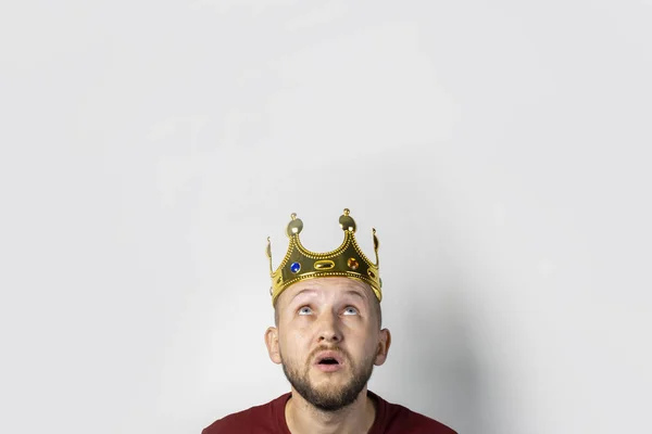 Young man with a crown on his head on a light background. Concept is king, luck, gain, rich, dream, goal, aspiration. Banner — Stock Photo, Image