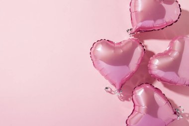 Pembe arka planda kalp şeklinde hava balonları. Doğal ışık. Pankart. Aşkı, düğünü, fotoğraf bölgesini düşün. Düz yatış, üst görünüm