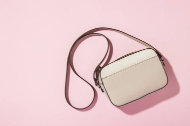 Pembe arka planda omzunun üzerinde uzun bir sapı olan Kadın Yorganı Çapraz Ceset Torbası. Moda ve güzellik kavramı, modern, şık. Düz yatış, üst görünüm
