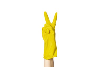 Temizlik için sarı lastik eldivenli bir kadın eli beyaz izole bir arka planda bir jest gösteriyor. İki parmak.