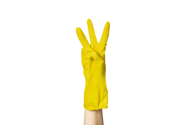 A female hand in a yellow rubber glove for cleaning shows a gesture on a white isolated background. Three fingers — Stock Photo, Image