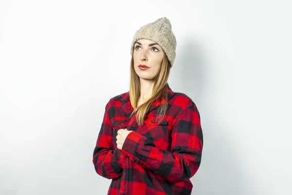 Junge Frau mit einem Lächeln im Hut, rotem Hemd und weißem T-Shirt vor weißem Hintergrund. Stylisches, winterliches Konzept, Teenager-Stil, Schock, Überraschung. Banner — Stockfoto