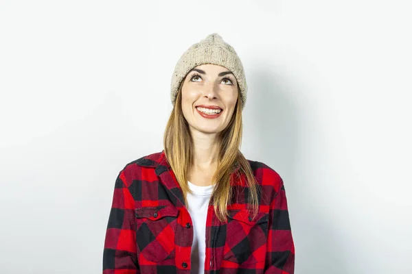 Eine junge Frau mit nachdenklichem Gesicht träumt von etwas mit Hut, rotem Hemd und weißem T-Shirt vor weißem Hintergrund. Stilvolles Konzept, Traum, Plan, Ziel, Teenager-Stil, Schock, Überraschung. Banner — Stockfoto