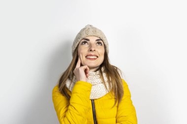 Sarı ceketli, şapkalı, parlak arkaplanlı, dalgın yüzlü genç bir kadın. Hayal et, düşün, seç, karar ver, planla. Pankart