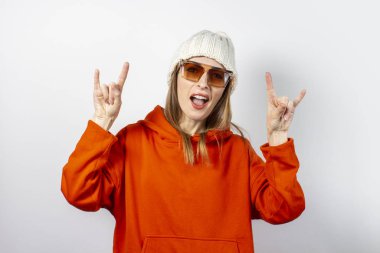 Kırmızı kapüşonlu, gözlüklü ve beyaz arka planda şapkası olan genç bir kadın. Modern tarz, gençlik, gençlik kavramları