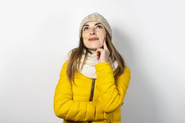 Sarı ceketli, şapkalı, parlak arkaplanlı, dalgın yüzlü genç bir kadın. Hayal et, düşün, seç, karar ver, planla. Pankart