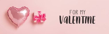 Pembe hava balonu kalp şeklinde pembe kurdeleli pembe bir hediye kutusu. Düğün konsepti, Sevgililer Günü, sevdiklerine bir hediye. Pankart. Düz yatış, üst görünüm