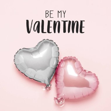 Pembe arka planda kalp şeklinde iki pembe hava balonu. Sevgililer Günü konsepti, düğün dekorasyonu. Folyo topları. Düz yatış, üst görünüm