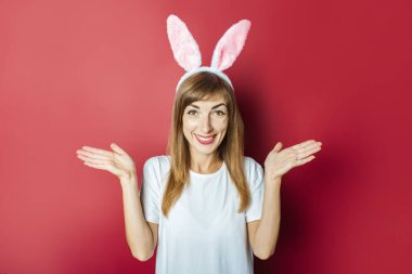 Pembe arka planda tavşan kulaklı güzel bir kadın. Paskalya konsepti