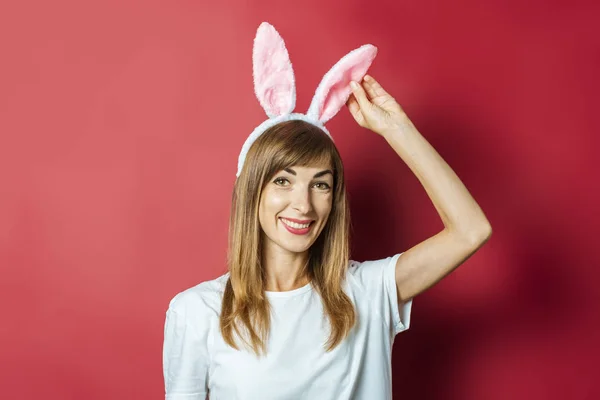 Jeune belle femme avec des oreilles de lapin sur un fond rose. Concept de Pâques — Photo