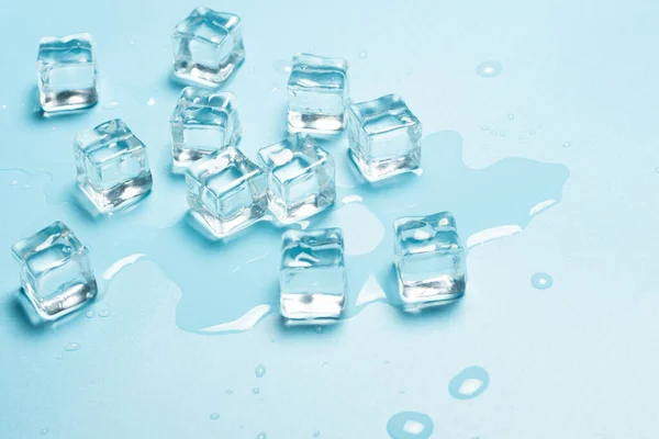 Cubos de hielo con agua sobre fondo azul. Concepto de hielo para bebidas. Banner. Piso tendido, vista superior —  Fotos de Stock