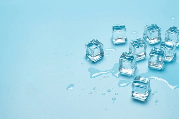 Παγάκια με νερό σε μπλε φόντο. Παγωμένη ιδέα για ποτά. Μπάνερ. Επίπεδο lay, πάνω όψη — Φωτογραφία Αρχείου