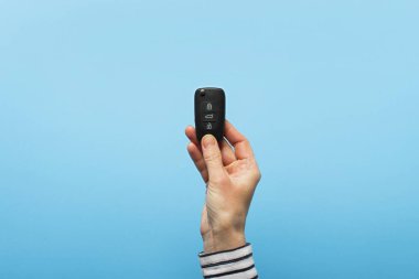 Kadın eli mavi arka planda arabanın anahtarlarını tutuyor. Konsept araba, araba kiralama, hediye, sürüş dersleri, ehliyet. Pankart. Düz yatış, üst görünüm