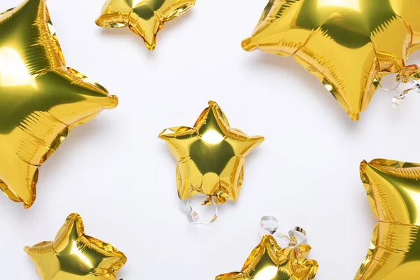 Air gouden ballonnen ster vorm en snoep op een witte achtergrond. Concept voor vakantie, feest, fotozone, decoratie. Banner Flat lay, bovenaanzicht — Stockfoto