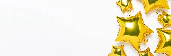 Aria palloncini d'oro a forma di stella e caramelle su uno sfondo bianco. Concetto per vacanza, festa, zona foto, decorazione. Banner Posa piatta, vista dall'alto — Foto Stock