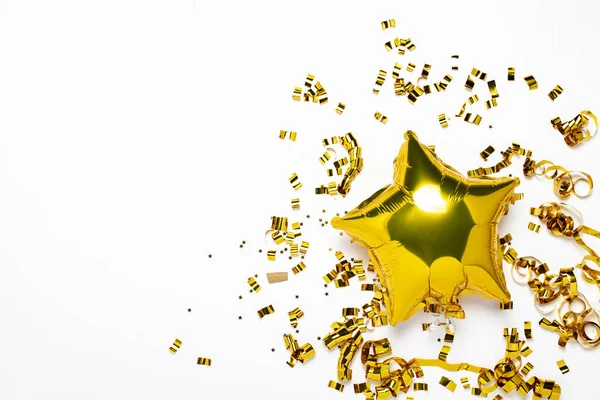 Globos dorados de aire con forma de estrella y confeti sobre fondo blanco. Concepto de fiesta, fiesta, cumpleaños, decoración. Banner Plano laico, vista superior —  Fotos de Stock
