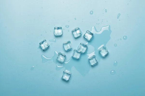 Cubos de hielo con agua sobre fondo azul. Concepto de hielo para bebidas. Banner. Piso tendido, vista superior —  Fotos de Stock