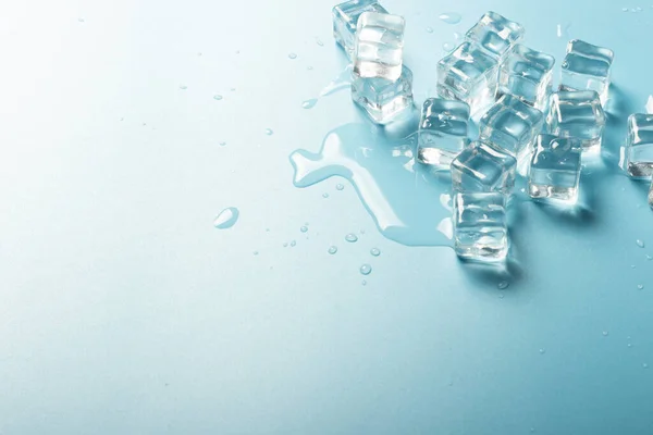 Cubos de hielo con agua sobre fondo azul. Concepto de hielo para bebidas. Banner. Piso tendido, vista superior —  Fotos de Stock