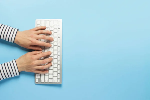 Female hands and keyboard on a blue background. Concept workspace, work at the computer, freelance, design. Banner. Flat lay, top view — Stock Photo, Image