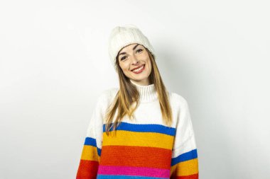Beyaz arka planda şapkası ve kazağı olan genç bir kadın. Kış, sonbahar, tarz, Noel, yeni yıl, sürpriz, şok. Pankart
