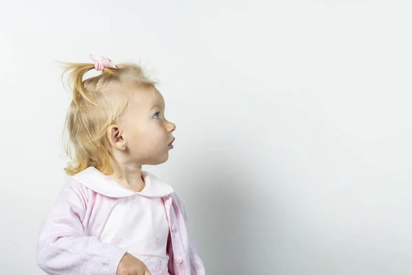 Criança pequena olha para um fundo leve. Menina de vestido — Fotografia de Stock