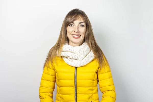 Mulher com uma jaqueta amarela e um lenço sobre um fundo branco. Roupa conceitual para outono, inverno, moda, estilo — Fotografia de Stock