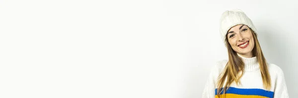 Junge Frau mit einem Lächeln im Hut und Pullover auf weißem Hintergrund. Konzept von Winter, Herbst, stilvoll, Weihnachten, Neujahr, Überraschung, Schock. Banner — Stockfoto