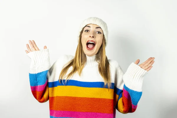 Jovem com um rosto surpreso em um chapéu e suéter em um fundo branco. Conceito de inverno, outono, elegante, Natal, Ano Novo, surpresa, choque. Banner — Fotografia de Stock