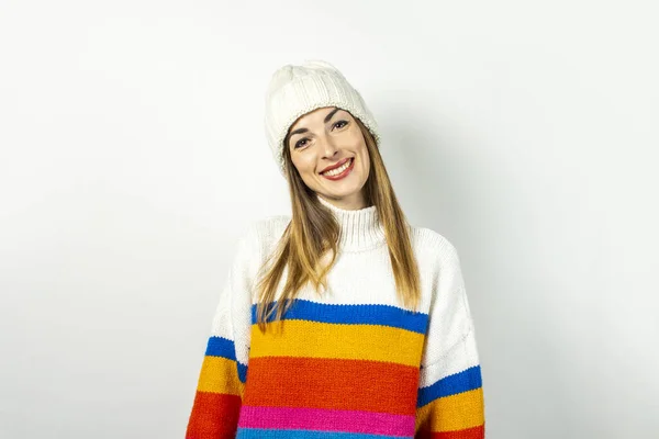 Giovane donna con un sorriso in un cappello e maglione su uno sfondo bianco. Concetto di inverno, autunno, elegante, Natale, Capodanno, sorpresa, shock. Bandiera — Foto Stock