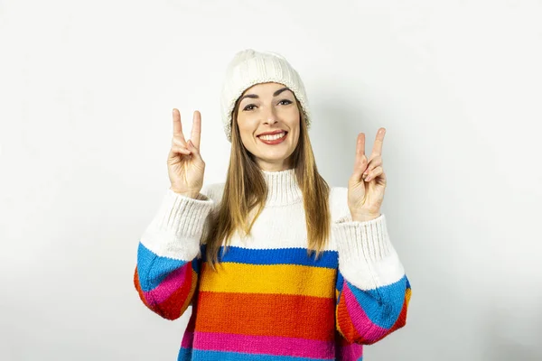 웃으며 모자를 쓰고 하얀 배경에 스웨터를 입은 젊은 여성. 겨울, 가을, 스타일, 크리스마스, 새해, 기습, 충격의 개념. 배너 — 스톡 사진