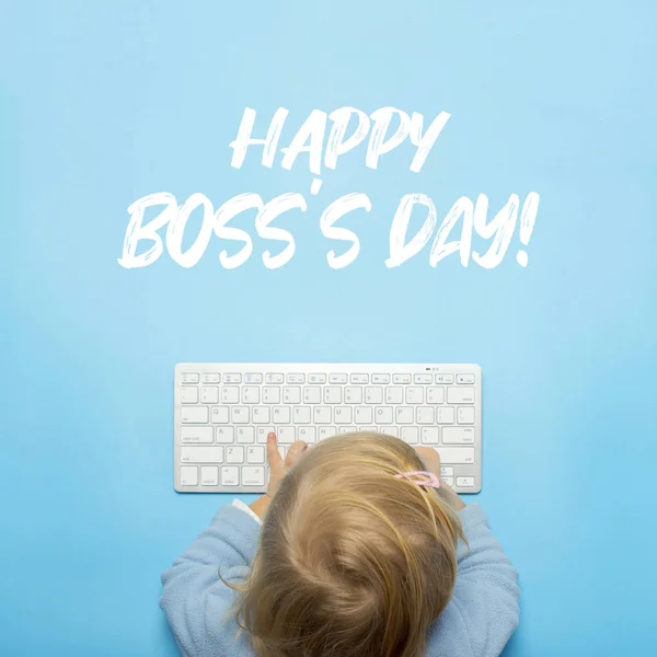 Niño pequeño sostiene las manos en el teclado sobre un fondo azul. Añadido la inscripción Feliz Día del Jefe. Vista superior, superior. Puesta plana — Foto de Stock