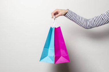 Kadın el, beyaz arka planda alışveriş torbaları tutuyor. Konsept alışveriş, indirim, indirim. Pankart
