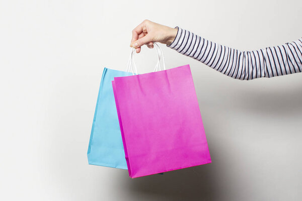 Female hand holds shopping bags on a white background. Concept shopping, discount, sale. Banner