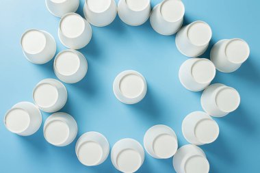 Bir fincan mavi arka plandaki içecekler için kağıt bardaklarla çevrilidir. Arkadaş canlısı takım, lider, yönetmen, patron. Pankart. Düz yatış, üst görünüm.