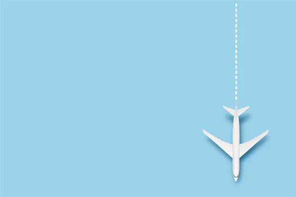 Airplane and line indicating the route on a blue background. Concept travel, airline tickets, flight, route pallet. Banner. Flat lay, top view.