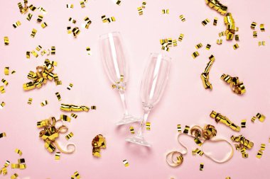 İki boş şampanya bardağı ve soluk pembe arka planda serpiştirilmiş altın konfeti. Düğün konsepti, doğum günü, yıldönümü, parti, bekarlığa veda partisi. Pankart.