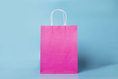 Mavi arka planda pembe çanta. Alışveriş paketi. Tatil, alışveriş, indirim kavramı. Pankart.