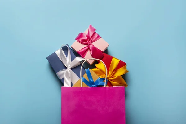 从粉色的包装盒掉到蓝色的背景上 礼品袋和礼品盒假期的概念 班纳俯瞰 — 图库照片